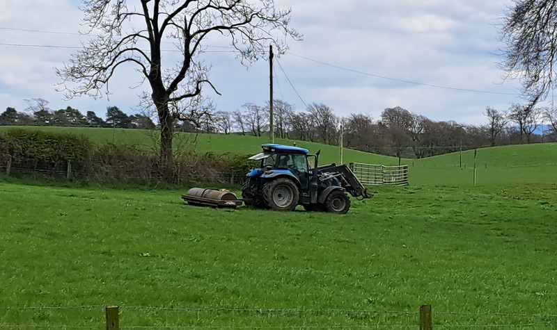 Farmer in tractor rolling a field